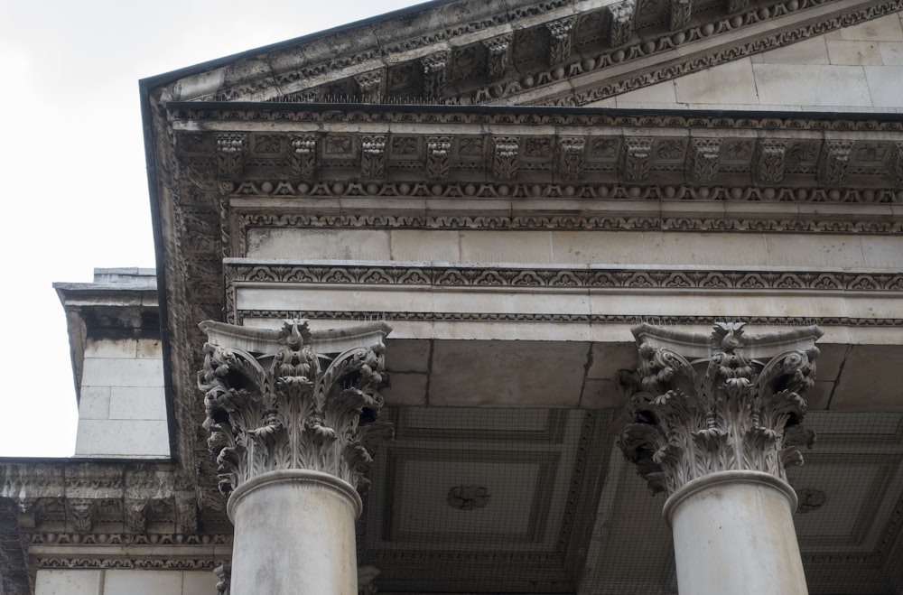 a close up of a building with columns and a sky background