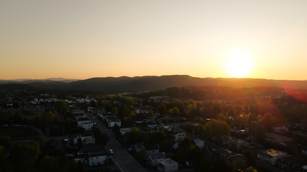 the sun is setting over a small town