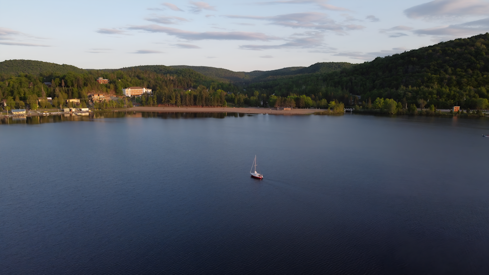 a boat floating on top of a lake surrounded by mountains