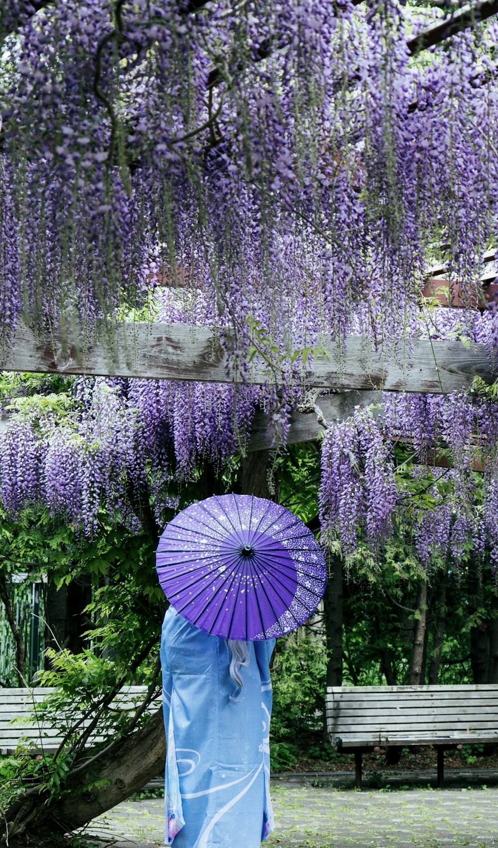 a woman in a blue dress holding a purple umbrella