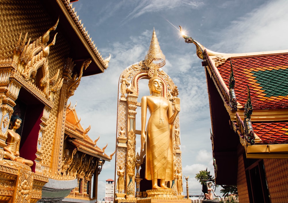 a large golden buddha statue in front of a building