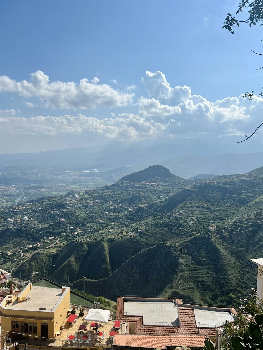 a view of a valley and mountains from the top of a hill