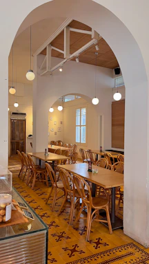Cozy dining area at saboréa with warm lighting and rustic wooden tables.