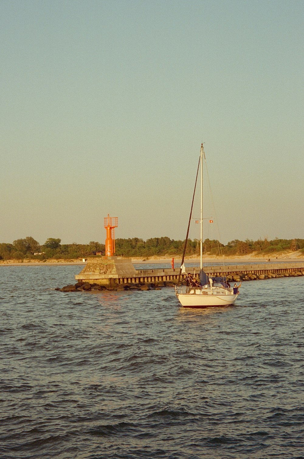 a sailboat in the water near a pier