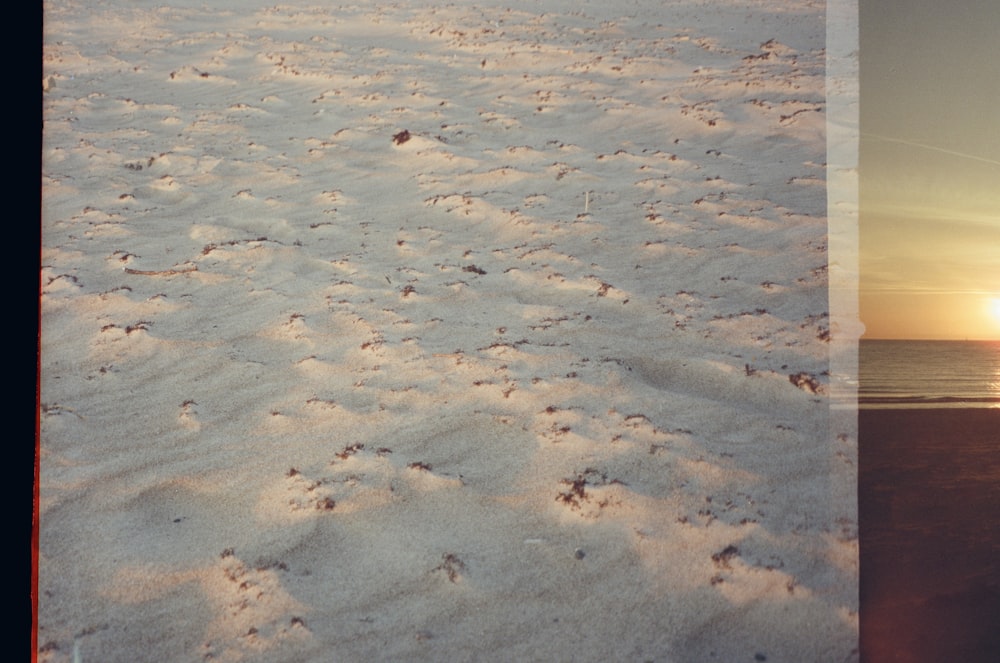 a picture of a beach with footprints in the sand