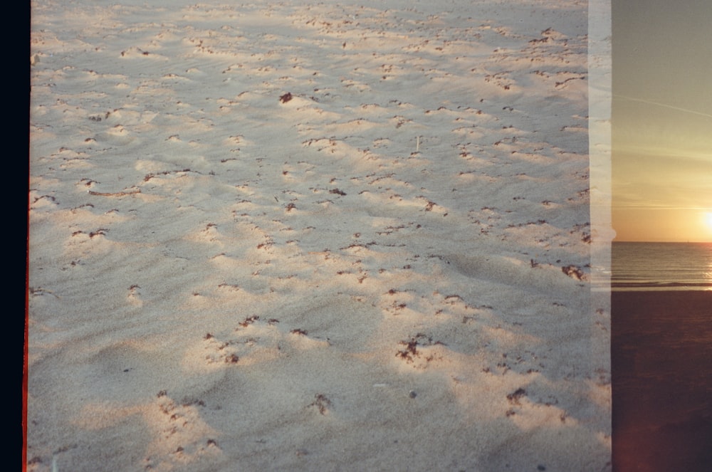 Una imagen de una playa con huellas en la arena