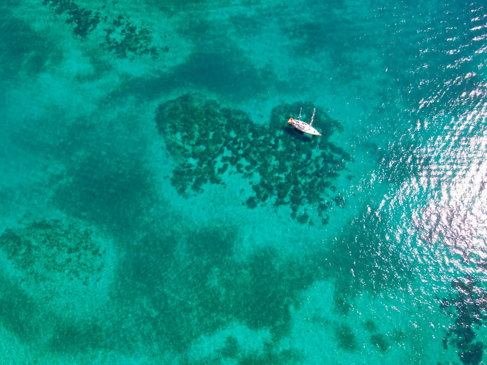 an aerial view of a boat in the ocean