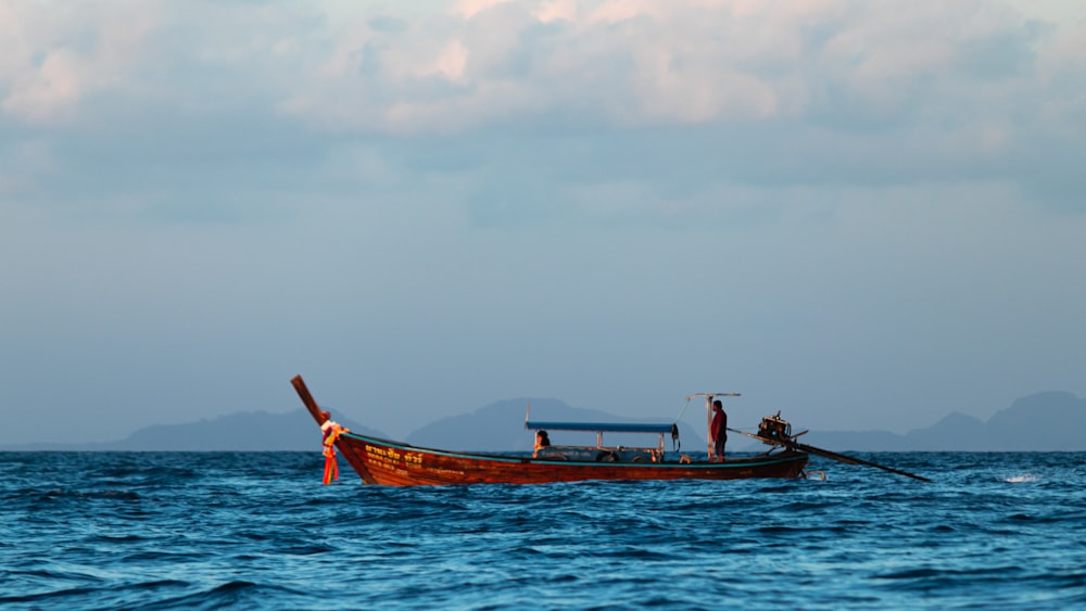 a boat with two people in it in the middle of the ocean