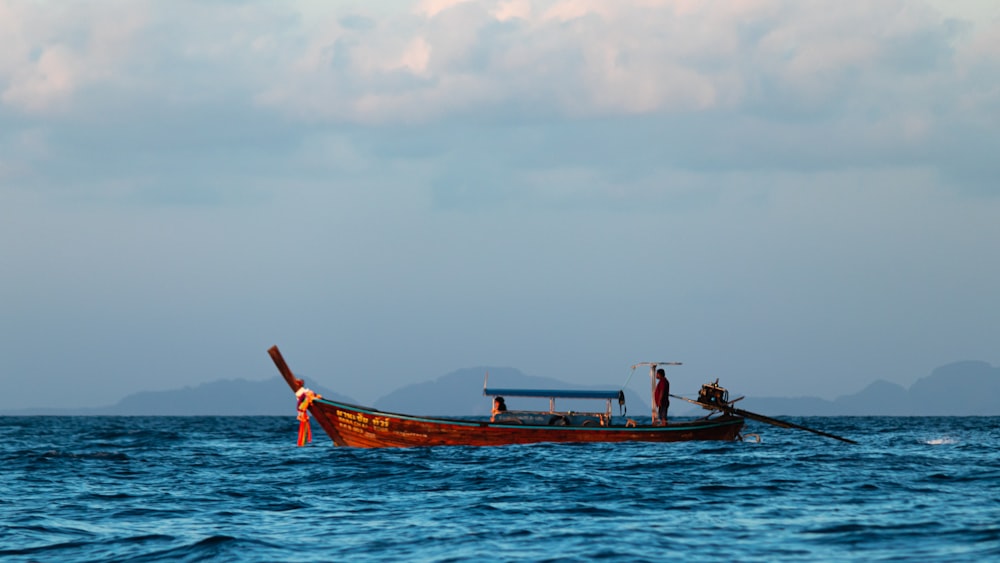 Una barca con due persone in mezzo all'oceano