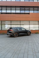 A sleek professional vehicle parked in front of a modern office building.