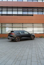 A sleek black car ready for Uber or VTC service parked in front of a modern building.