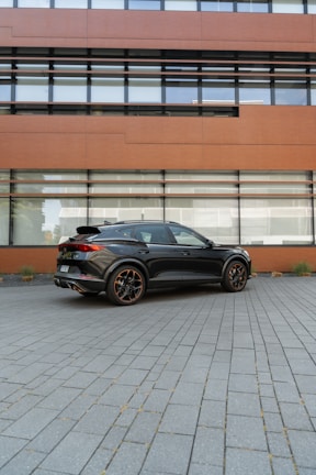 A sleek private transport van parked outside a modern office building.
