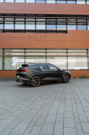 A sleek professional vehicle parked in front of a modern office building.