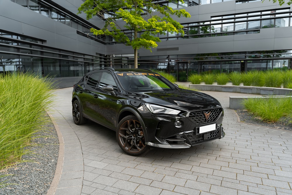 ein schwarzer SUV, der vor einem Gebäude geparkt ist