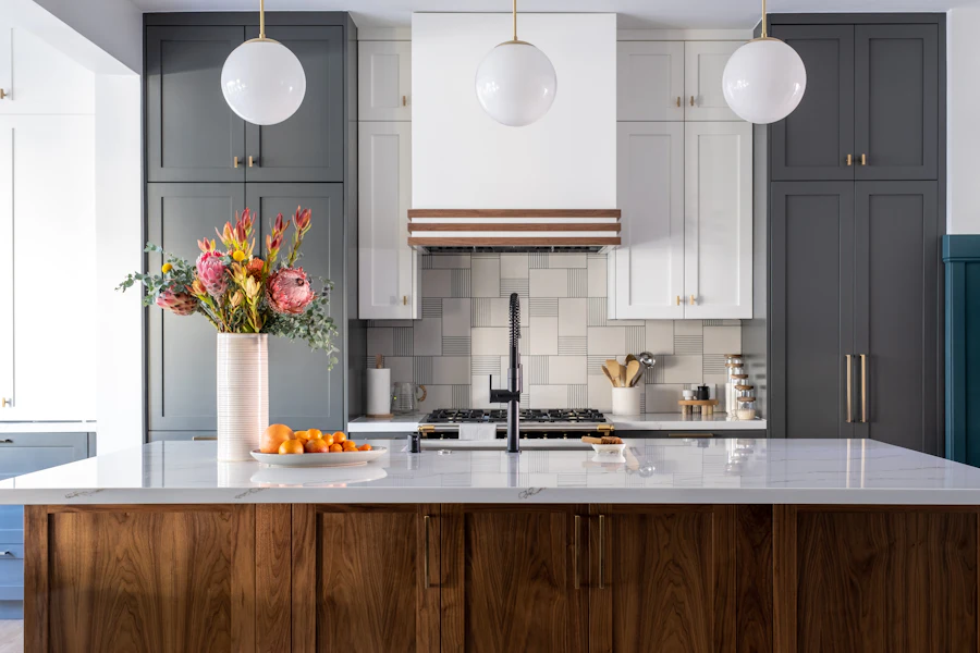 A kitchen with white upper cabinets, a walnut island and a marble counter
