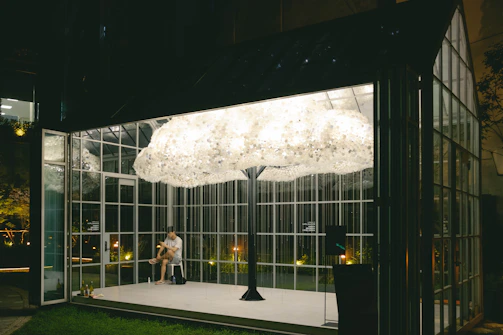 Minimalist art installation featuring translucent cloud forms suspended from the ceiling.