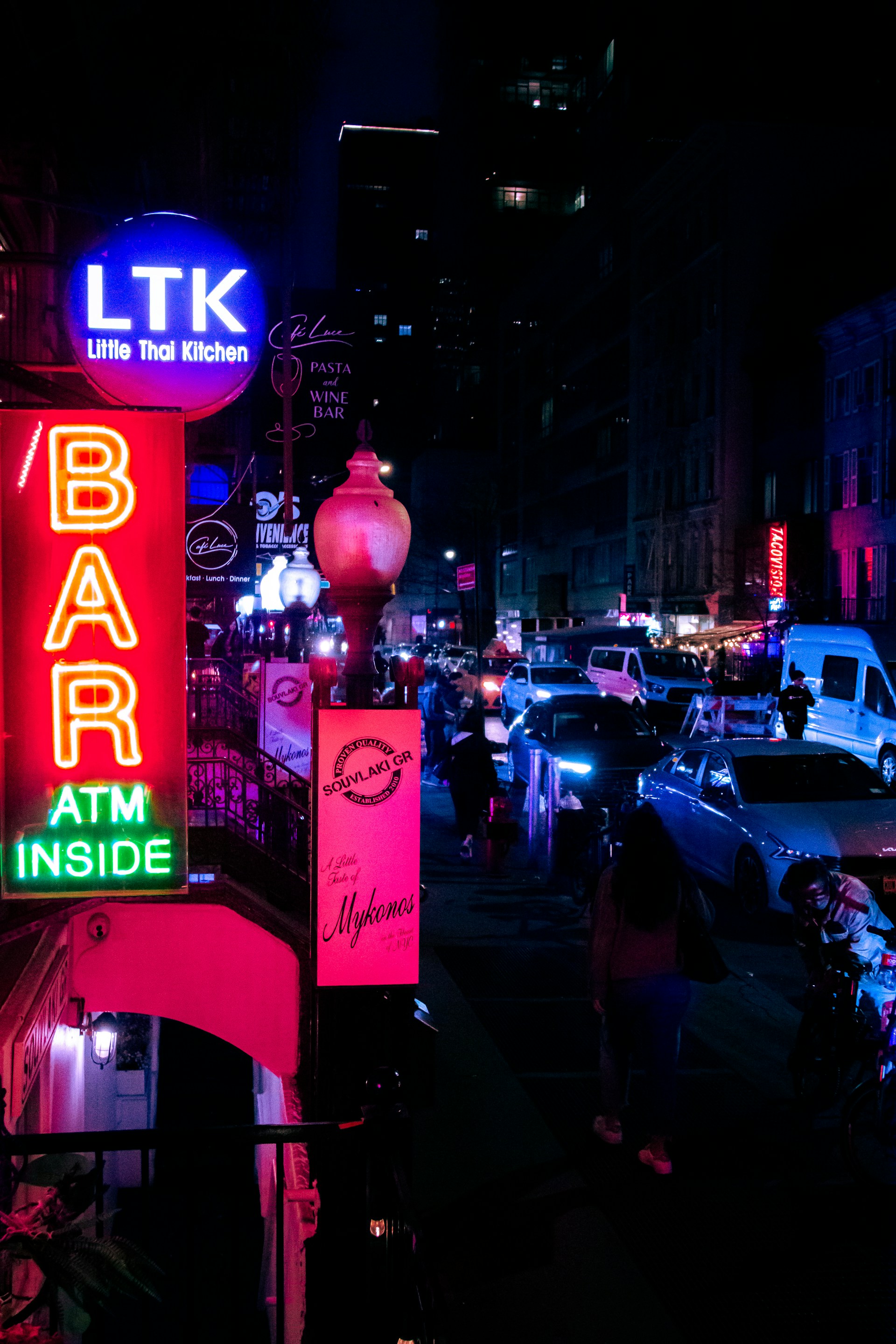 A vibrant street scene in Bangkok at dusk, with neon signs glowing and locals bustling through a narrow alley.