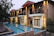 A sleek modern villa with a luxurious pool at dusk, illuminated by warm lights.