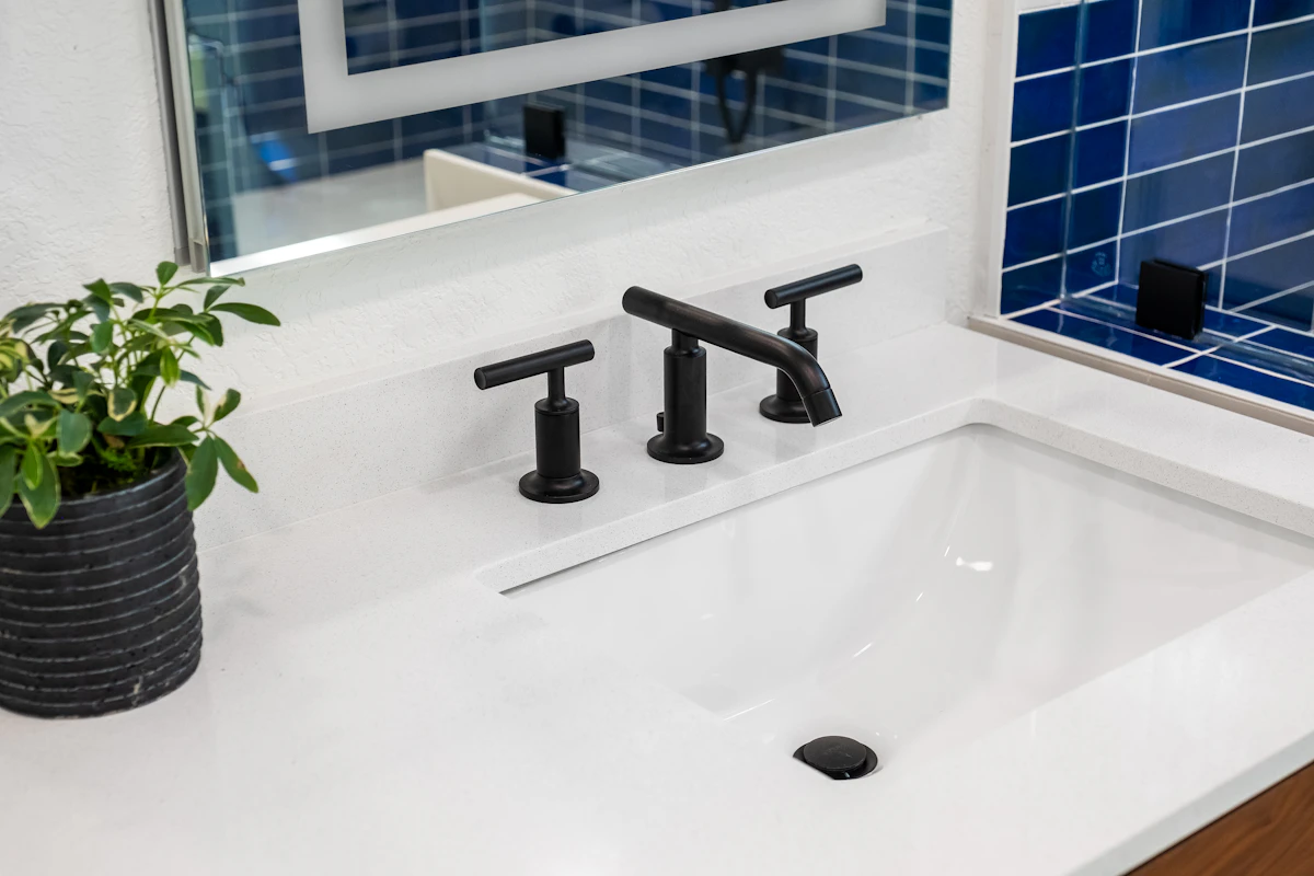 Mavi fayans kaplı banyo duvarı ve lavabo