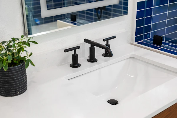 Mavi fayans kaplı banyo duvarı ve lavabo