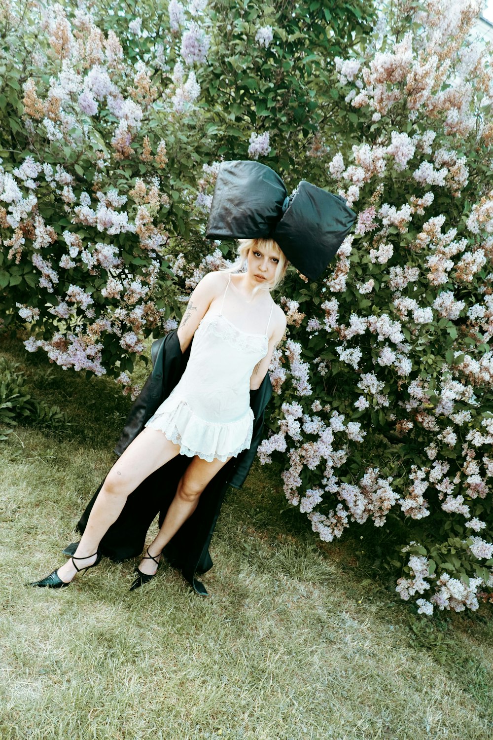 a woman in a white dress and black hat