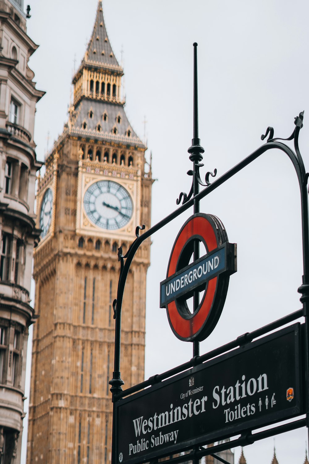 a street sign with a clock tower in the background