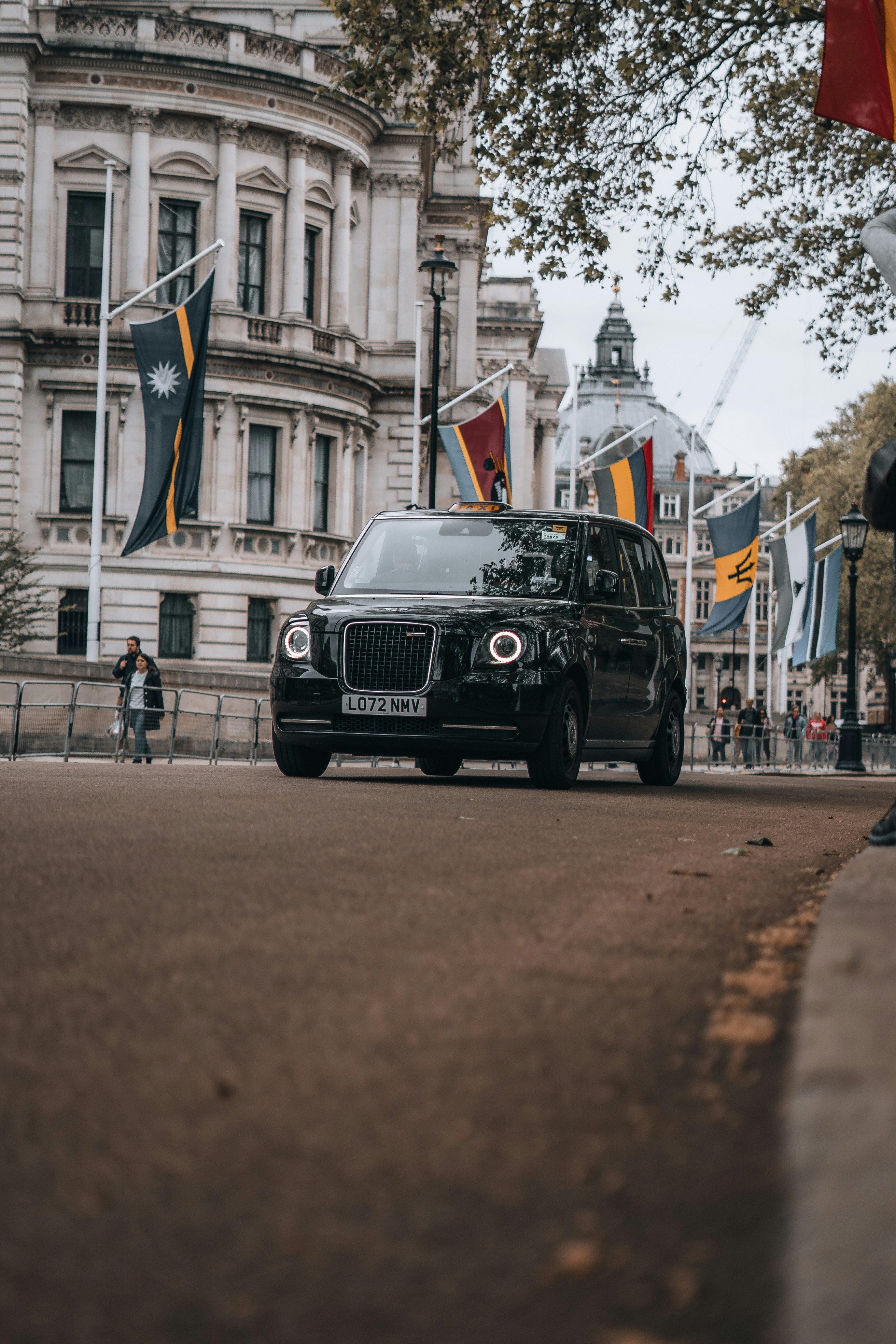 Un'auto nera che percorre una strada accanto a un edificio alto