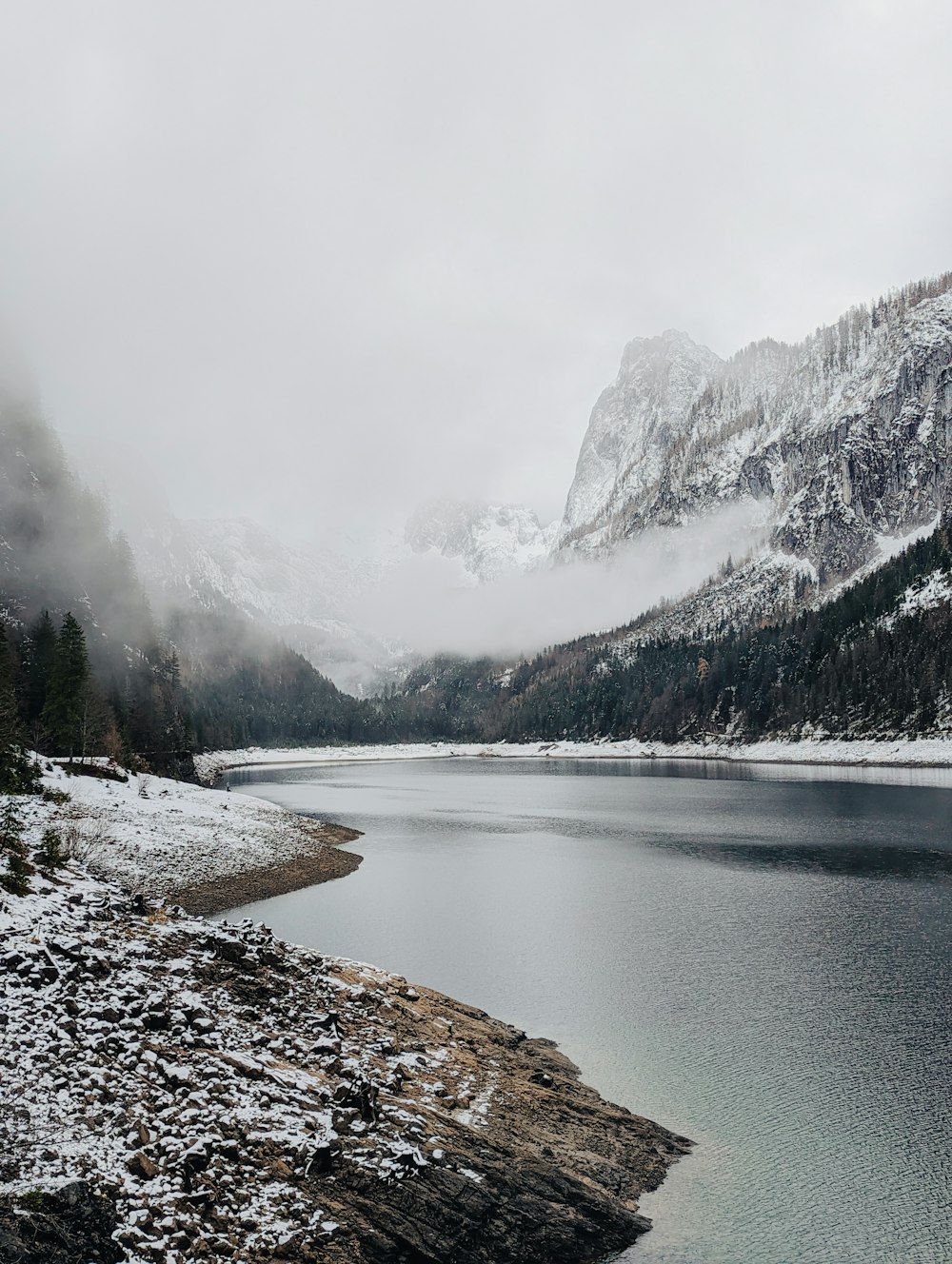 a large body of water surrounded by snow covered mountains