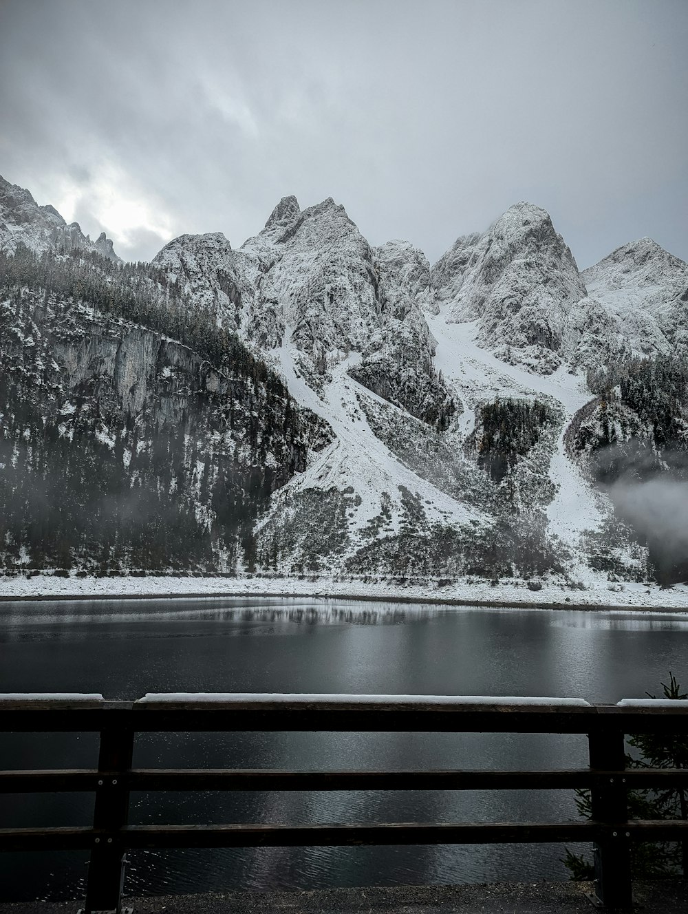 a bench sitting in front of a mountain covered in snow