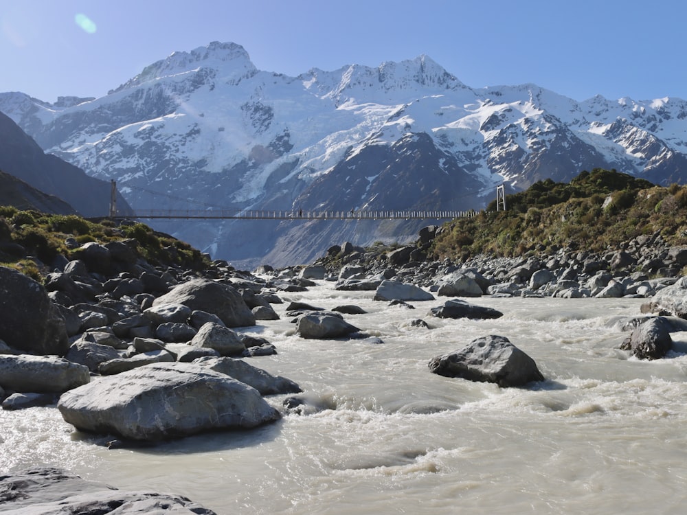 a mountain range with a suspension bridge over a river