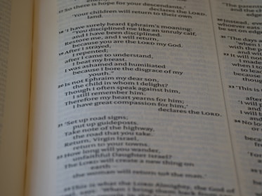 A close-up view of an open book displaying printed text. The focus is on a section of the page with a passage discussing themes of repentance and compassion. The text appears to be religious or philosophical in nature.