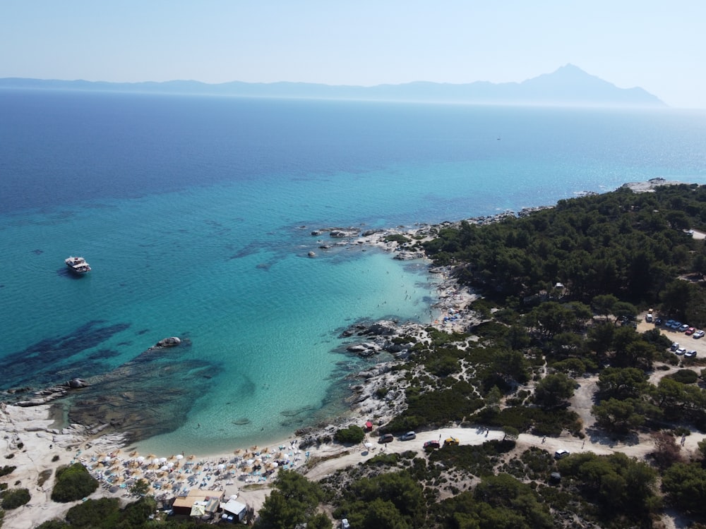 an aerial view of a beach with a boat in the water