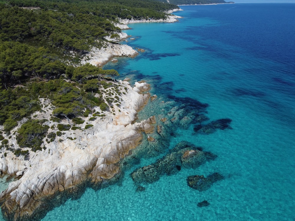 an aerial view of a beach with clear blue water