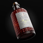 A detailed, ornate bottle featuring a textured surface and a label with intricate typography. The bottle contains a reddish-brown liquid and has an elegant, vintage design style.