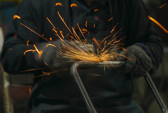 welder working on a piece of metal with sparks