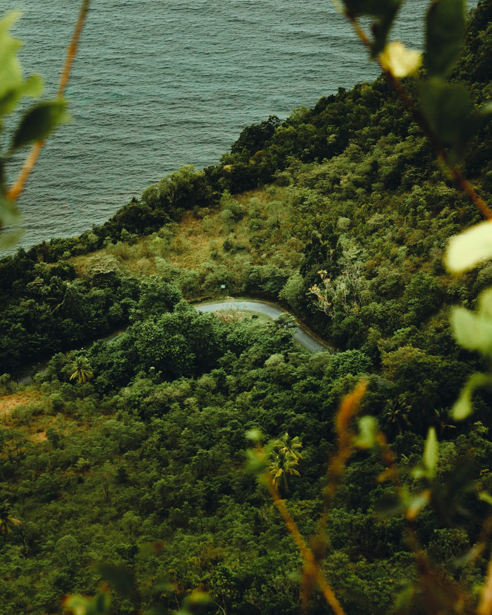 a winding road on the side of a hill next to a body of water