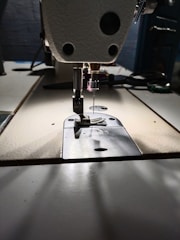 A close-up of a sewing machine with fabric and threads.