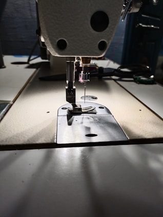 A close-up of a sewing machine with fabric and threads.