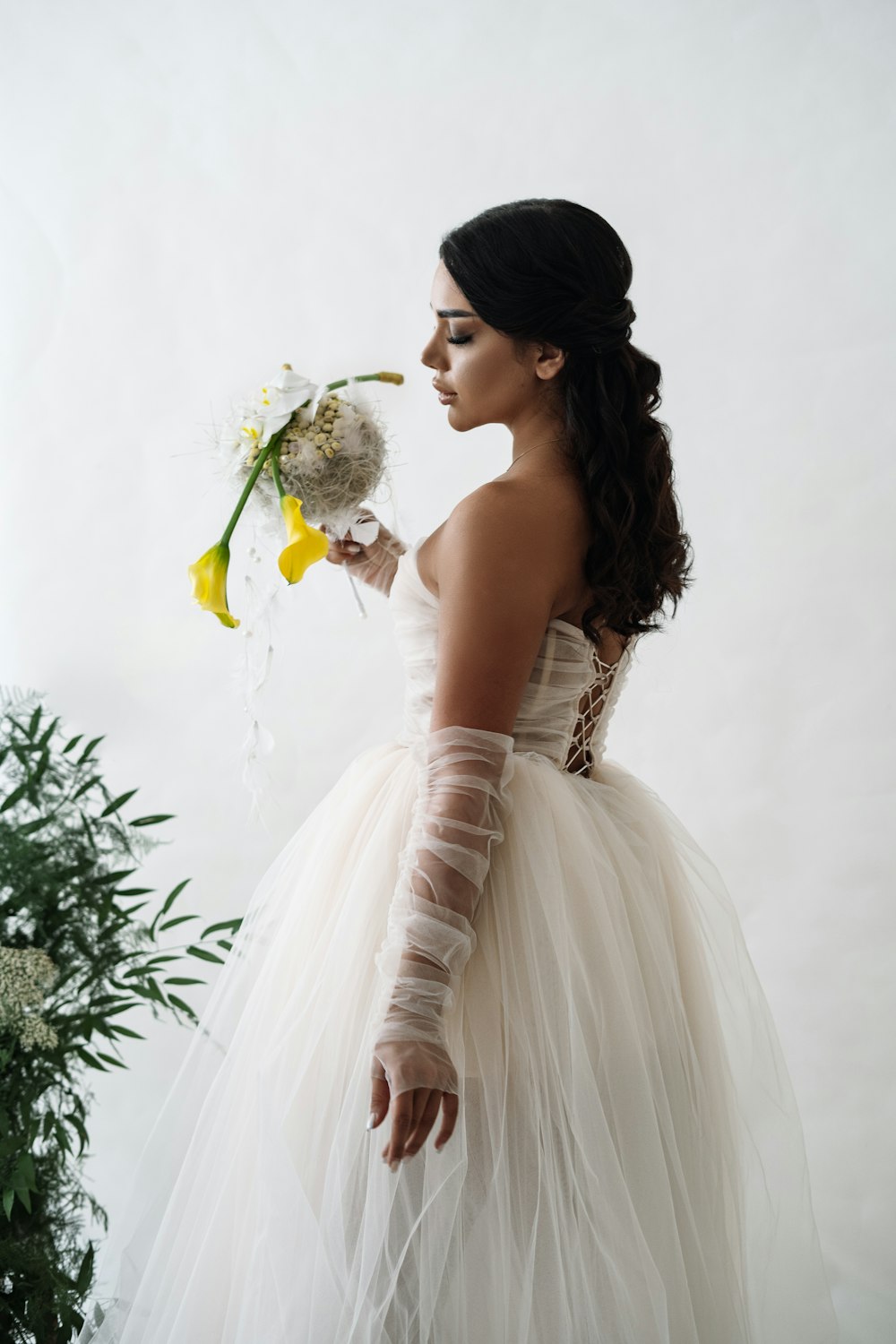 a woman in a white dress holding a bouquet of flowers