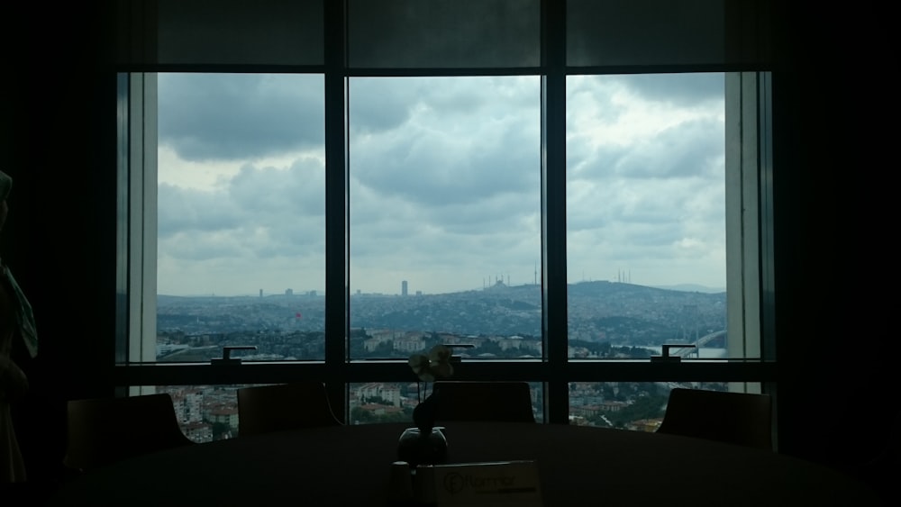 a person sitting at a table looking out a window