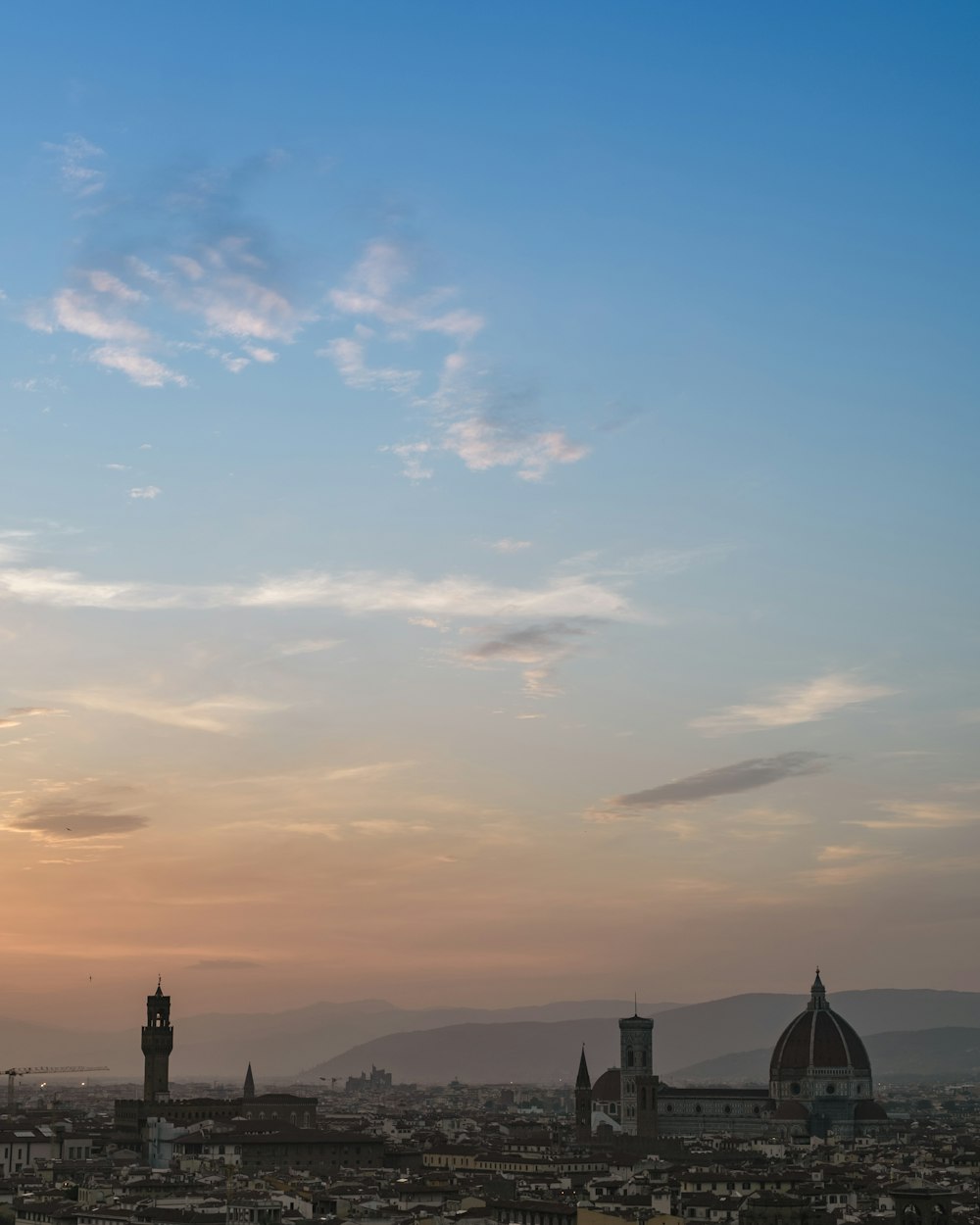 the sun is setting over a city with tall buildings