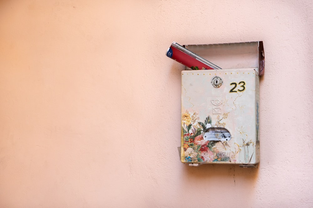 a mailbox mounted to a wall with a pen sticking out of it