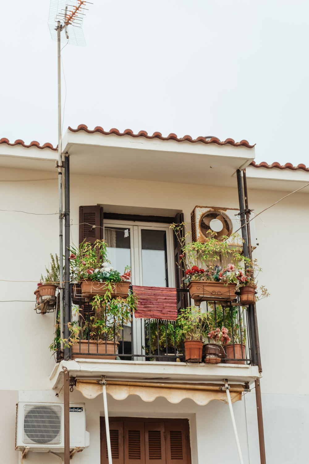 a balcony with potted plants and a fan