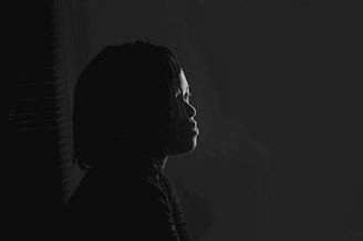 a black and white photo of a person in the dark