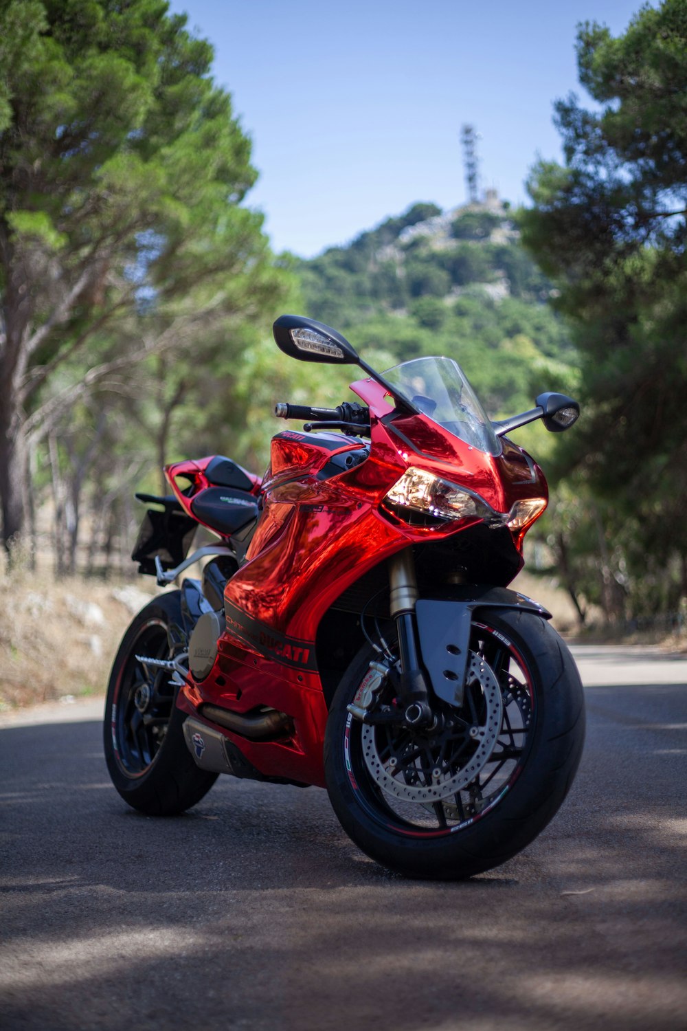 a red motorcycle parked on the side of a road