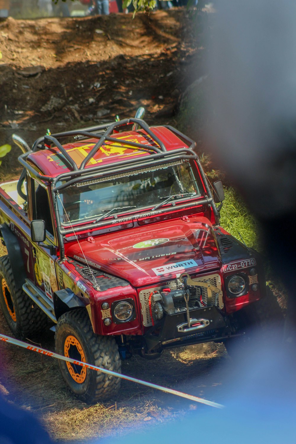 a red jeep driving down a dirt road