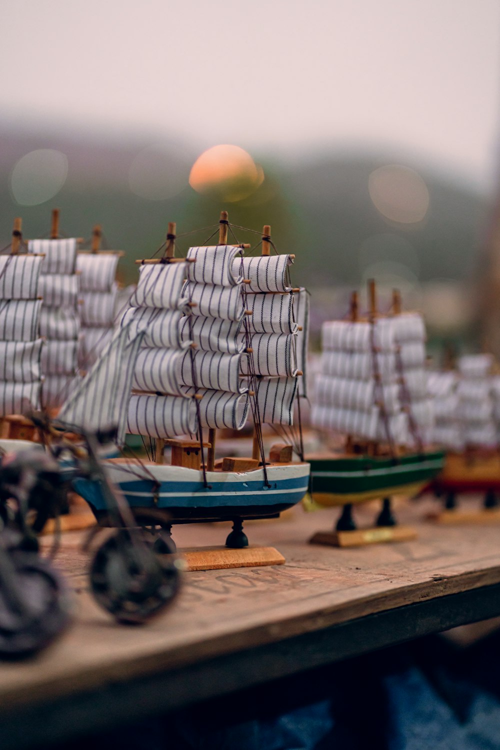 a wooden table topped with lots of toy boats