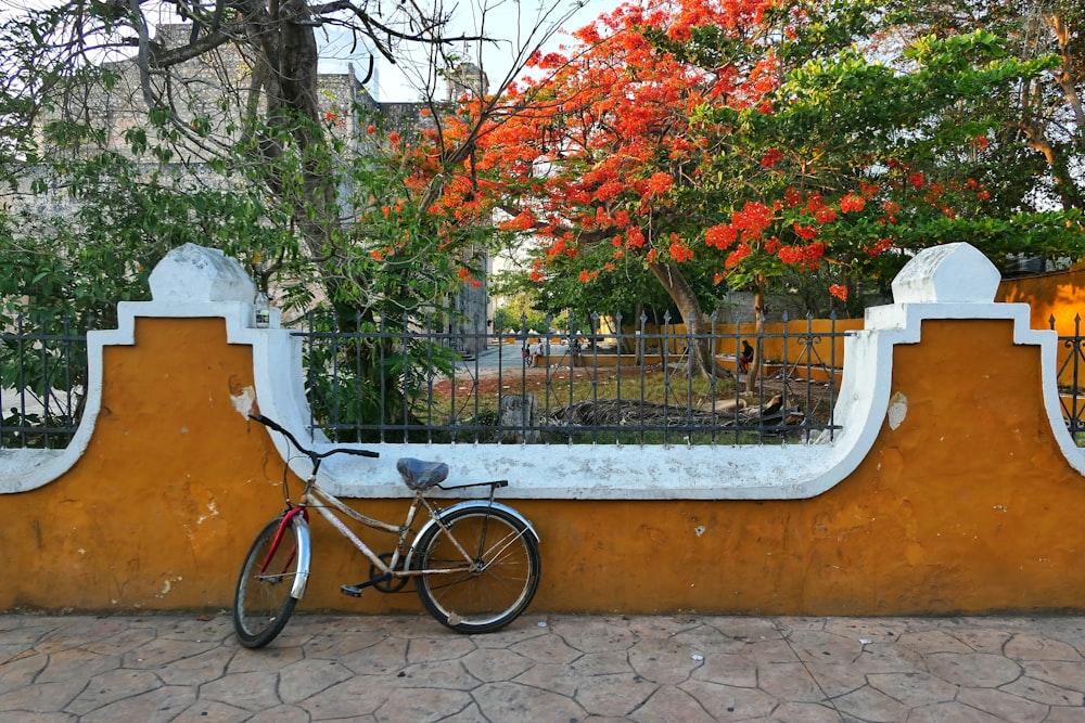 una bici parcheggiata contro un muro con un cancello