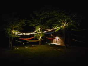 Sunset view over the hostel's vibrant outdoor lounge area with hammocks and fairy lights