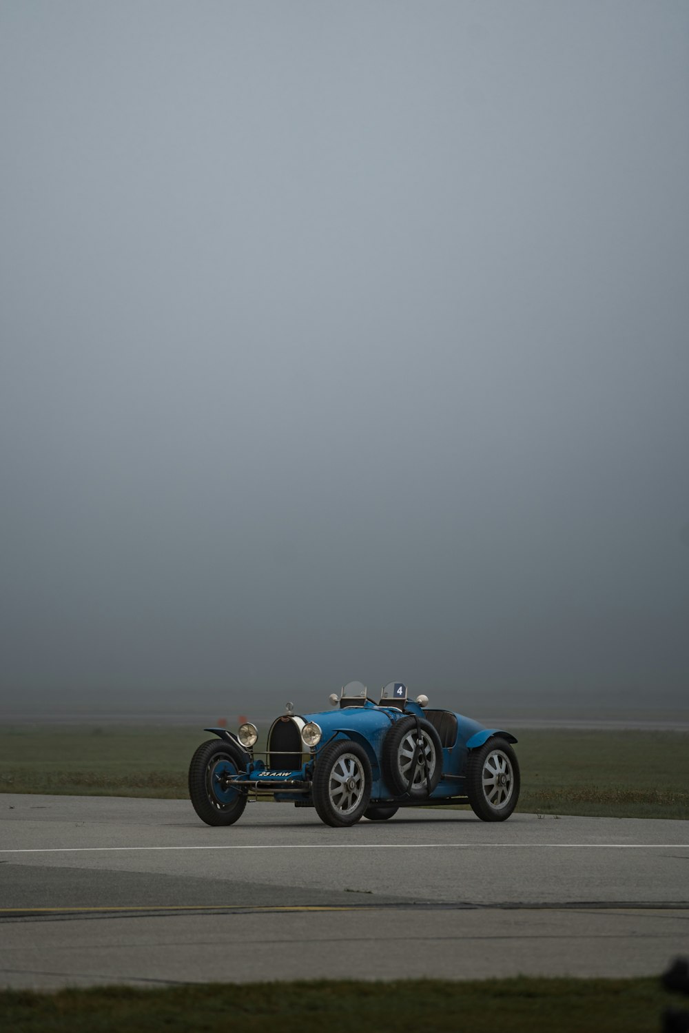 a blue race car driving down a runway